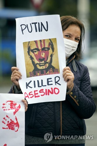 3월 6일 에콰도르 수도 키토에서 한 여성이 블라디미르 푸틴 러시아 대통령을 '살인자'로 묘사한 포스터를 들고 시위를 하고 있다. AFP=연합 
