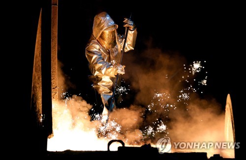 독일 뒤스부르크에 있는 티센크루프사의 제철소에서 작업자가 조철 샘플을 들어올리고 있다. 티센크루프는  석탄을 사용해 철강 제품을 생산했으나, 이산화탄소 배출량을 줄이기 위해 수소환원제철로의 전환을 추진하고 있다. 철강은 1차로 탄소국경조정제도가 적용되는 업종이다. EPA=연합