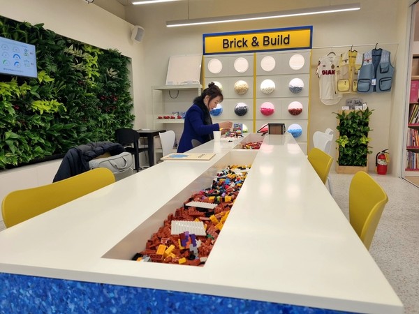 폐 장난감의 새활용 제품 '브릭'으로 작품을 만들고 있는 문준필 환경교육 교사. 사진=이가은