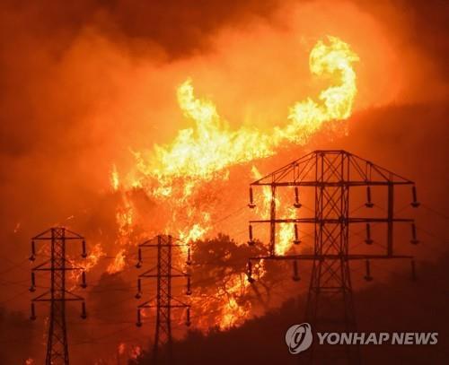 해마다 대규모 산불로 피해가 급증하는 미 서부 캘리포니아에서 산불로 송전탑까지 타고 있다. 사진=AP연합뉴스