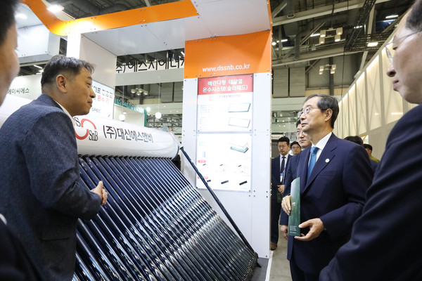 ​한덕수 국무총리가 27일 부산 해운대구 벡스코 2023 기후산업국제박람회(WCE)에 참가한 삼성 전시관을 찾았다. 기후 변화에 대응하는 친환경 보일러와 태양광 전지 패널 등을 살펴보고 있다. 사진=연합뉴스(국무총리실 제공)​