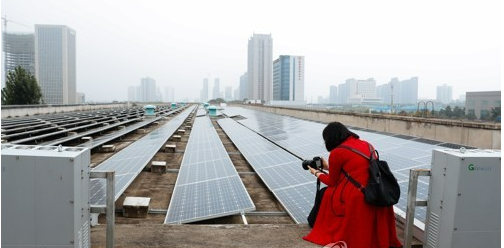 2018년 9월26일 한 기자가 중국 산시성 건축물 융기실리콘자재 지붕에 설치된 태양광 전지판을 촬영하고 있다. EPA=연합