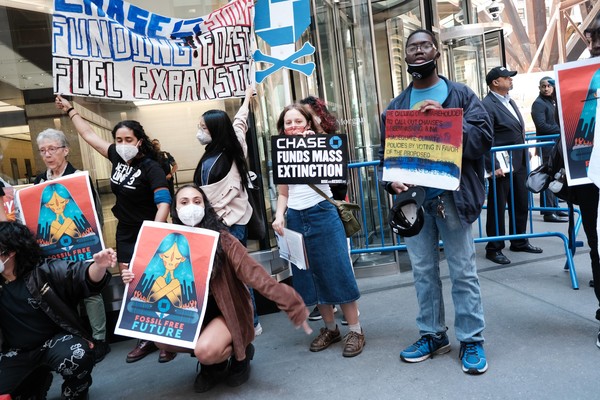 기후변화를 유발하는 화석연료를 없애자는 내용의 피켓을 들고 있는 JP모건 주총장 앞의 시위대. 사진=AP연합뉴스