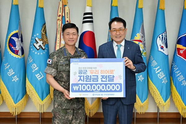 장광익 우리금융지주 부사장(오른쪽)이 이영수 공군참모총장에게 '우리 히어로'를 위한 지원금을 전달한 뒤 기념사진을 촬영하고 있다. 사진=우리금융