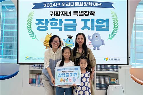 우리다문화장학재단 관계자가 지난 21일 베트남 귀환 다문화가정 자녀에 특별장학금을 전달한 뒤 기념사진을 촬영하고 있다. 사진=우리금융 