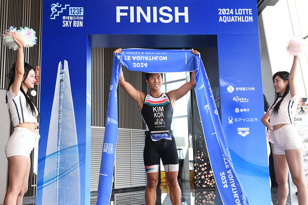 14일 오전 서울 송파구 롯데월드타워 앞 석촌호수에서 열린 2024 롯데 아쿠아슬론에서 수직마라톤인 스카이런을 마친 참가자들이 결승선을 통과하고 있다. 사진=연합뉴스