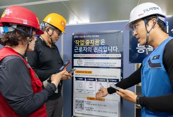 DL이앤씨 현장 안전관리자(오른쪽 첫 번째)가 현장 근로자들에게 안전신문고 접속 및 작업중지권 사용법에 관해 설명하고 있다. 사진=DL이앤씨