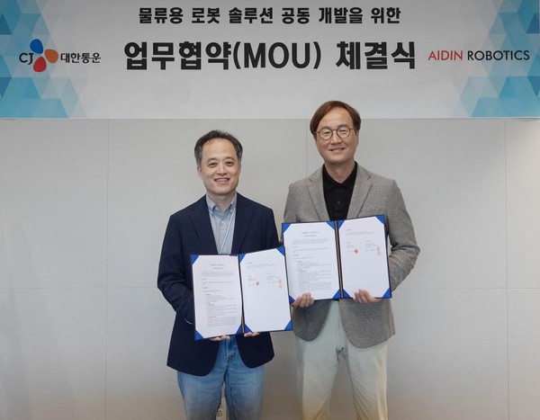 지난 24일 CJ대한통운 본사에서 진행된 MOU 체결 행사에서 김정희 CJ대한통운 TES물류기술연구소장(왼쪽)과 최혁렬 에이딘로보틱스 대표가 협약서를 들고 기념사진을 찍고 있다. 사진=CJ대한통운