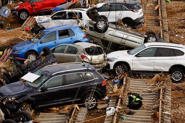 지난 1일 (현지 시각) 스페인 발렌시아의 알파파르에서 시민 경비대원이 폭우로 철도 선로에 올라앉은 차량 아래에서 희생자를 수색하고 있다. [로이터=연합뉴스]