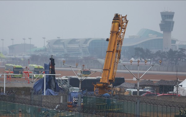 제주항공 여객기 참사 8일째인 5일 비가 내리는 무안국제공항 사고 현장과 꼬리 날개에 방수포가 덮여 있다. [연합뉴스]