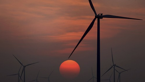 텍사스주 맥쿡의 풍력 발전소 뒤로 해가 지고 있다. AP=연합뉴스