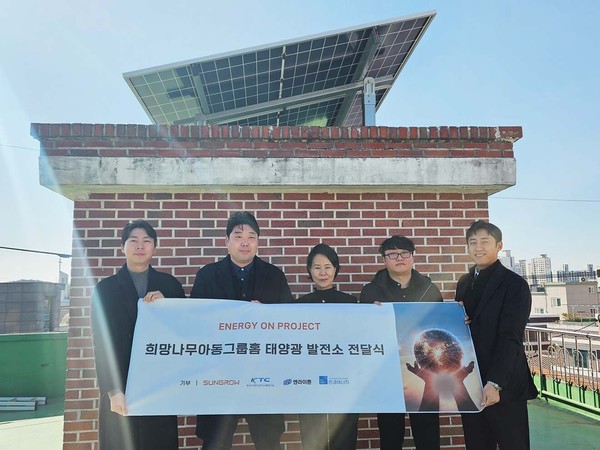 엔라이튼 관계자(오른쪽 2번째)와 최연순 희망나무그룹홈 원장(가운데)이 청주 희망나무그룹홈 옥상에 설치된 태양광 발전 설비 앞에서 관계자들과 함께 기념촬영을 하고 있다.  사진=엔라이튼