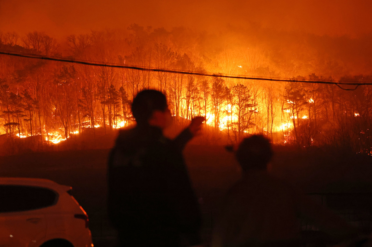 25일 경북 안동시 남선면 마을에서 주민들이 야산에 번진 산불을 바라보고 있다. 사진=연합뉴스