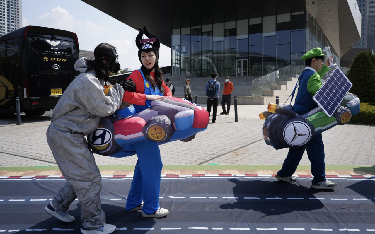 ASL, 환경운동연합, 빅웨이브 등 국내외 기후환경단체 등이 10일 일산 킨텍스 제1전시장 앞에서 현대차가 경쟁사에 뒤처지는 퍼포먼스를 통해 탈탄소 경쟁에서의 부진을 상징적으로 보여주고 있다. 사진=ASL