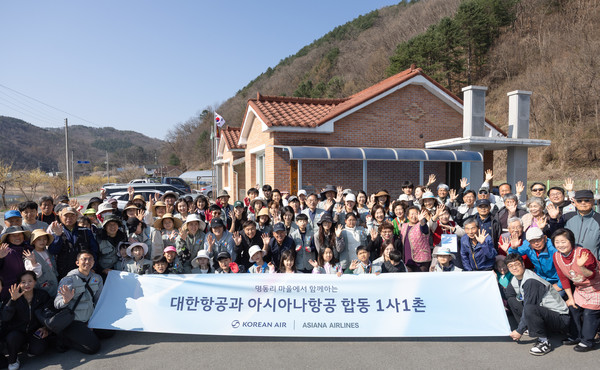 지난 11일 강원 홍천군 명동리 마을에서 봉사활동에 참여한 대한항공·아시아나항공 양사 임직원과 가족들이 명동리 주민들과 기념사진을 촬영하고 있다.   사진=대한항공
