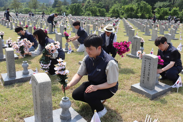 현충원을 찾은 LIG넥스원 신익현 대표이사와 신입 사원들이 자매결연 묘역 정화 활동을 벌이고 있다.  사진=LIG넥스원