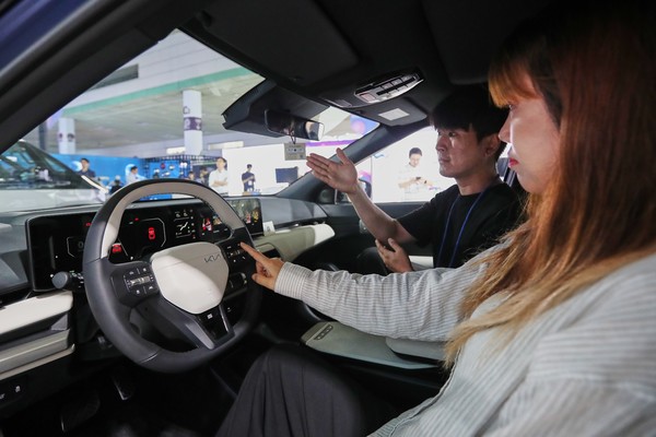 관람객이 AI가 적용된 EV4에서 AI 어시스턴트 기능을 체험하는 모습.   사진=현대차그룹