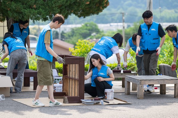 쿠팡로지스틱스서비스 임직원들이 지난 19일 아동보육시설 '꿈이 있는 마을'에서 야외평상 페인팅 작업을 하고 있다. 사진=쿠팡
