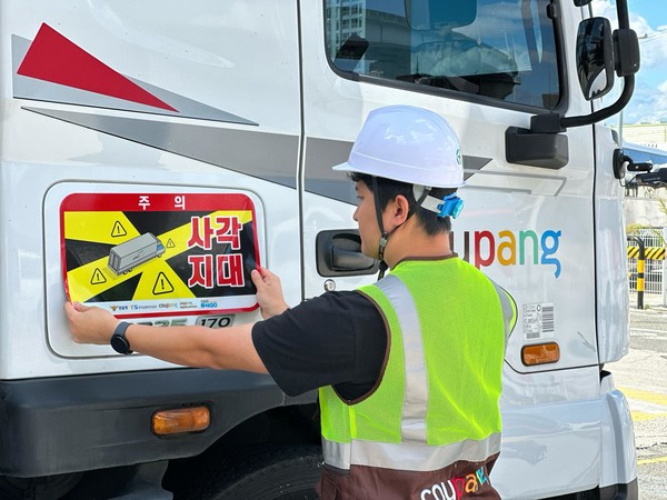 쿠팡·쿠팡로지스틱스서비스 대형 화물차에 '사각지대 주의' 알림 표지를 부착하는 모습.   사진=쿠팡