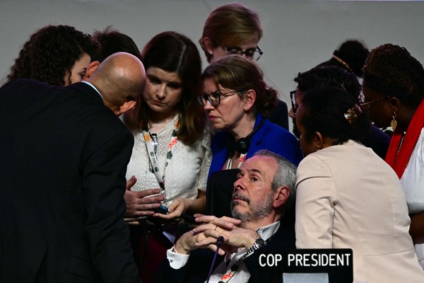 COP30의 안드레 코레아 두라고 의장(가운데)이 폐막일을 하루 넘긴 11월 22일 막판 합의를 시도하면서 참모들의 이야기를 듣고 있다. 두라고 의장은 개막 전기존의 ‘합의 중심 구조’를 ‘이행 중심 거버넌스’로 이행하겠다는 의지를 밝혔다.  [AFP=연합뉴스]